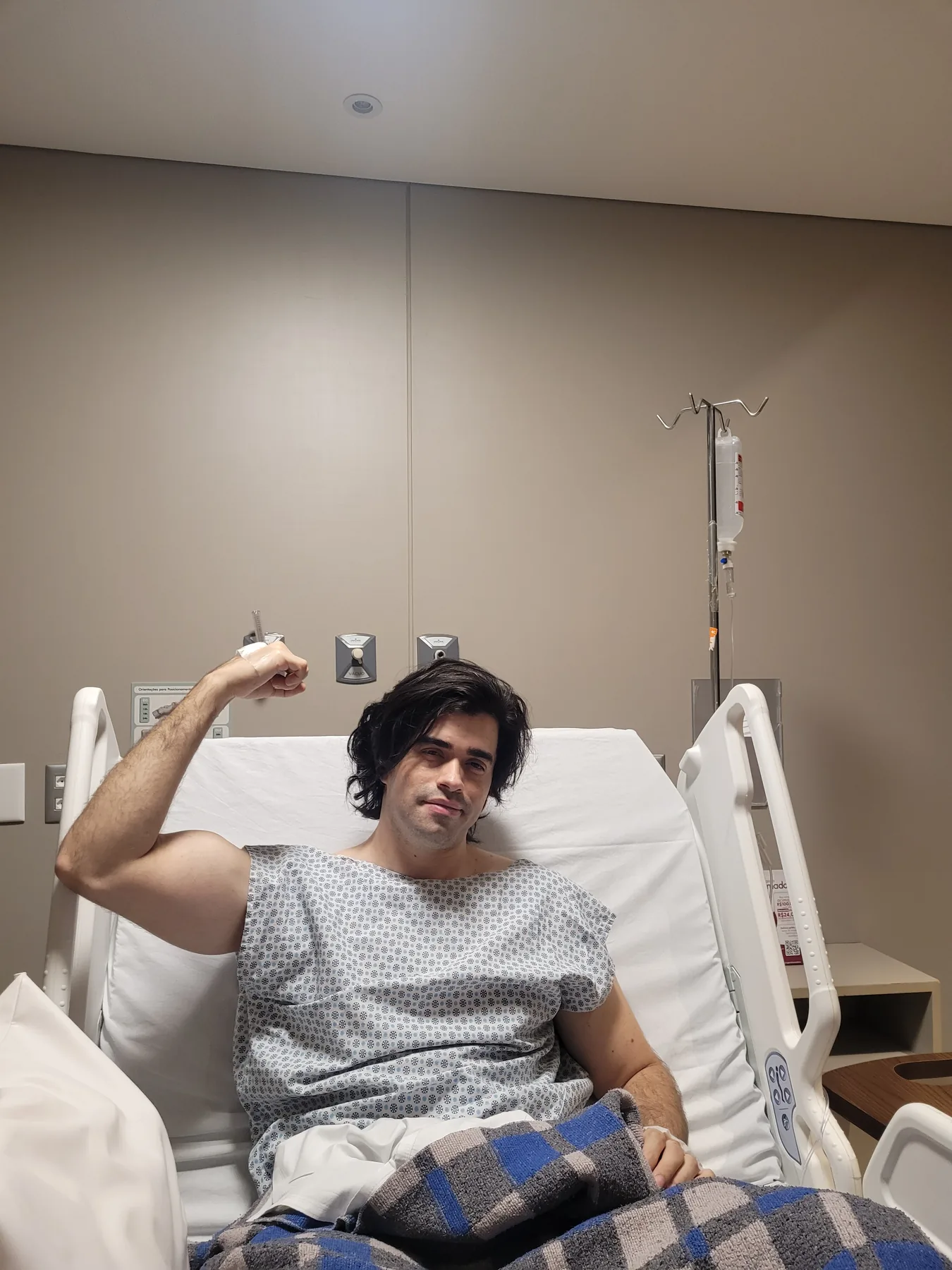 Gigio no hospital durante o tratamento em 2024, erguendo o braço em sinal de força