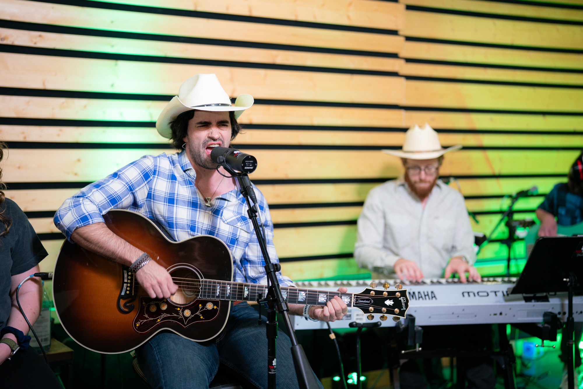 Gigio Teixeira cantando e tocando violão com a banda no Top Track Studios
