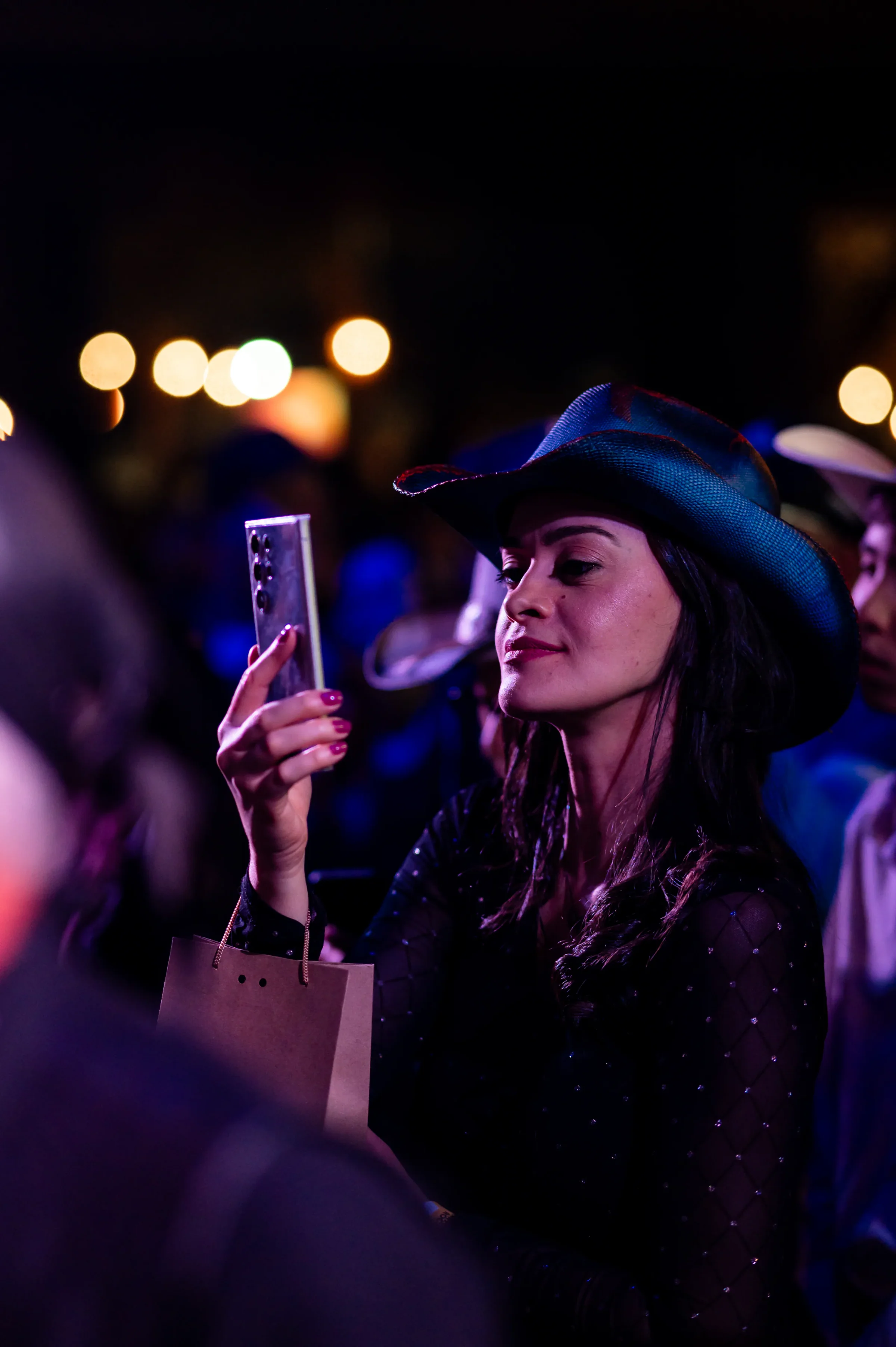 Mulher de chapéu registra o show de Gigio Teixeira com o celular