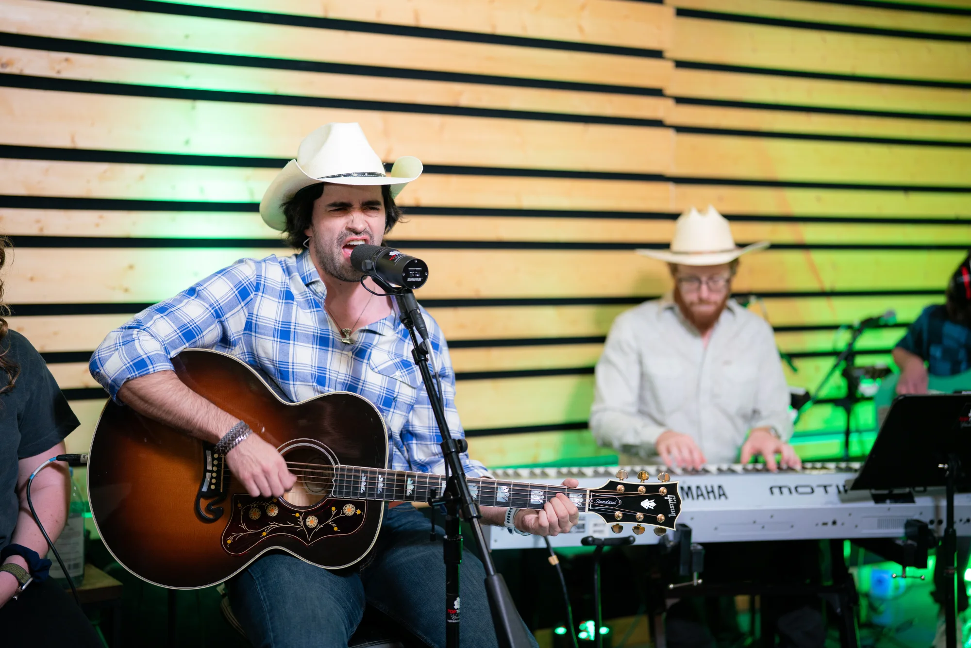 Gigio Teixeira cantando e tocando violão com a banda no Top Track Studios